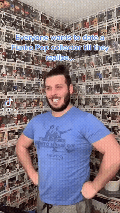 A Man Standing In Front Of A Wall Of Funko Pop Figures GIF