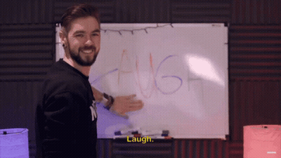 A Man Standing In Front Of A White Board That Says Laugh GIF