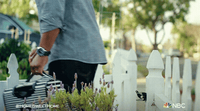 A Man Standing In Front Of A White Picket Fence With The Hashtag #Homesweethome On The Bottom GIF