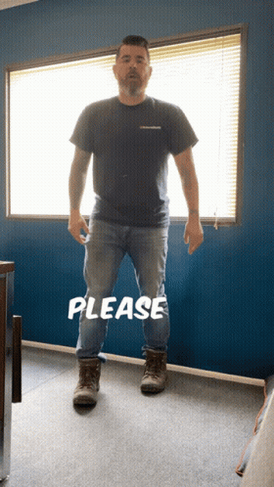 A Man Standing In Front Of A Window With The Word Please Written On The Floor GIF