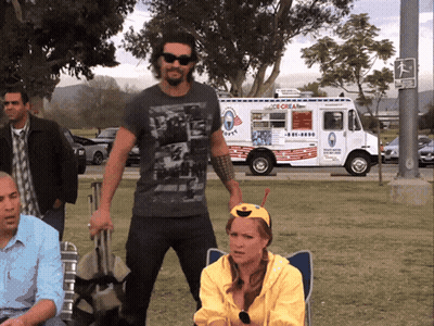 A Man Standing In Front Of An Ice Cream Truck That Says Ice Cream GIF