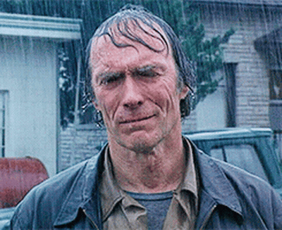 A Man Standing In The Rain With Wet Hair GIF