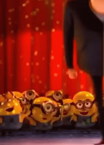 A Man Standing Next To A Bunch Of Minions GIF
