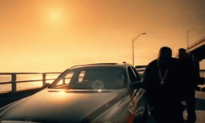 A Man Standing Next To A Car With The Sun Shining Through The Windshield GIF