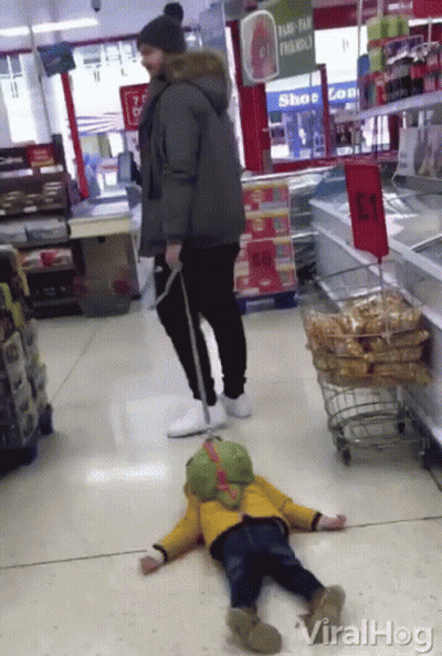 A Man Standing Next To A Child Laying On The Floor In A Store With A Sign That Says " Ramp-Tan Friendly " GIF