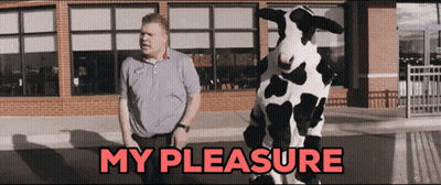A Man Standing Next To A Cow Costume That Says " My Pleasure " GIF