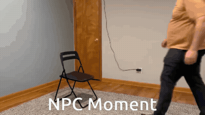A Man Standing Next To A Folding Chair With The Words Npc Moment On The Floor GIF
