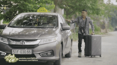 A Man Standing Next To A Honda Car With A Taxi Sign On The Top GIF