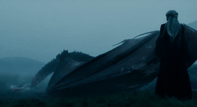 A Man Standing Next To A Large Dragon In A Field GIF