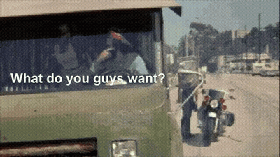 A Man Standing Next To A Motorcycle With The Words " What Do You Guys Want " On The Bottom GIF