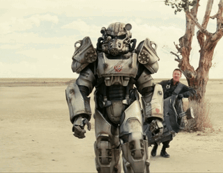 A Man Standing Next To A Robot In A Field GIF