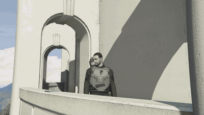 A Man Standing On A Balcony In Front Of A Building GIF