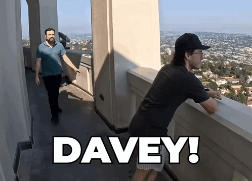 A Man Standing On A Balcony With The Word Davey On The Bottom Right GIF