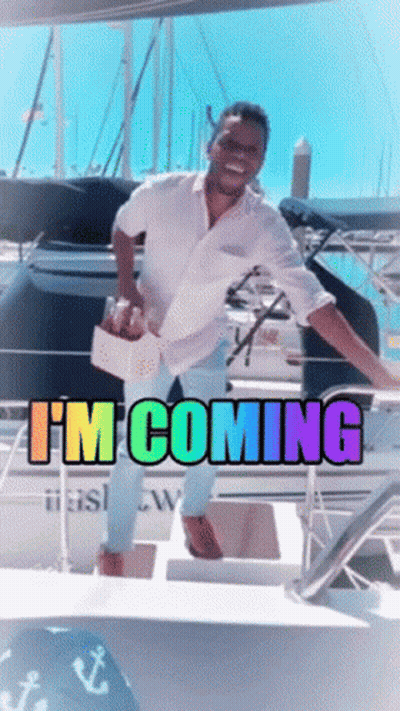 A Man Standing On A Boat With The Words " I 'M Coming " On It GIF