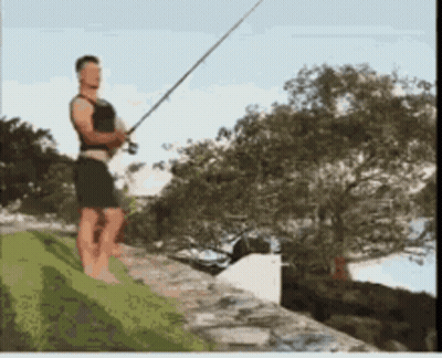 A Man Standing On A Ledge Holding A Fishing Pole GIF