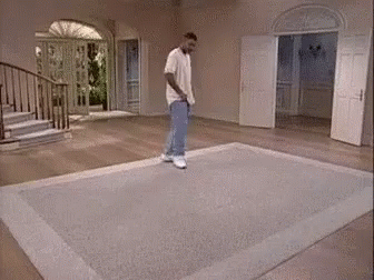 A Man Standing On A Rug In A Room GIF