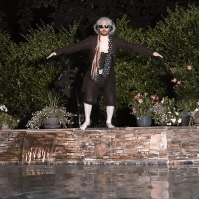 A Man Standing On A Stone Wall Next To A Pool GIF