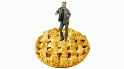 A Man Standing On Top Of A Large Pie GIF