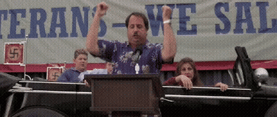 A Man Stands At A Podium In Front Of A Sign That Says Veteran 'S We Sal GIF