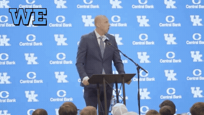 A Man Stands At A Podium In Front Of A Wall With Central Bank Logos On It GIF