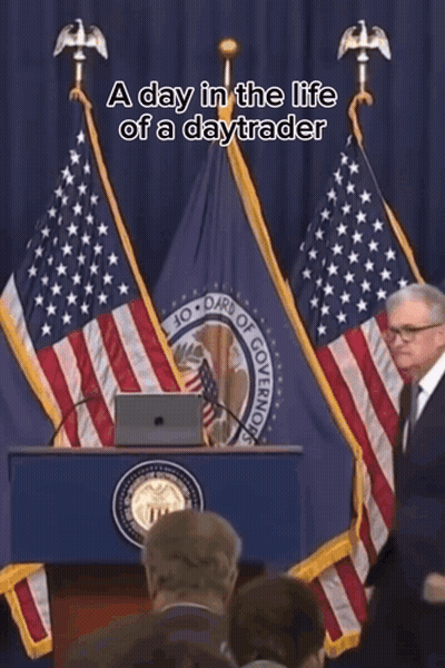 A Man Stands At A Podium In Front Of An American Flag With The Words A Day In The Life Of A Daytrader Above Him GIF