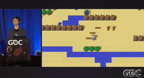 A Man Stands At A Podium With A Gdc Logo On It GIF