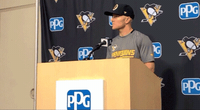 A Man Stands Behind A Podium With A Penguins Shirt On GIF