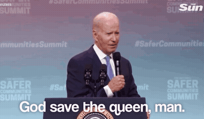 A Man Stands Behind A Podium With The Words God Save The Queen Man GIF