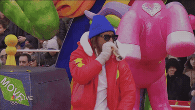 A Man Stands In Front Of A Box That Says Move Live On It GIF