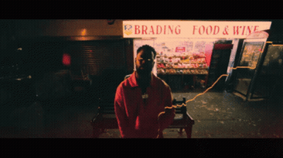 A Man Stands In Front Of A Brading Food And Wine Store GIF