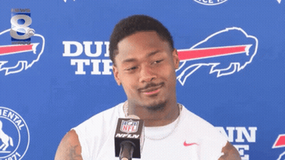 A Man Stands In Front Of A Buffalo Bills Banner GIF