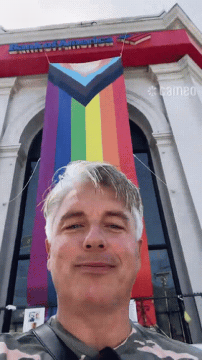 A Man Stands In Front Of A Building That Says Armored America On It GIF