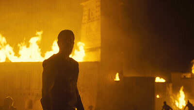 A Man Stands In Front Of A Burning Building With The Number 1 On It GIF