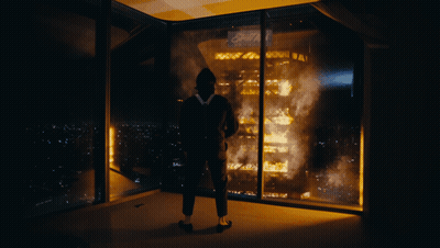 A Man Stands In Front Of A Burning Building With The Word Ford On The Top GIF