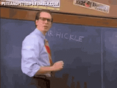 A Man Stands In Front Of A Chalkboard That Says " Mr Hickle " GIF