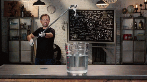 A Man Stands In Front Of A Chalkboard With Equations GIF