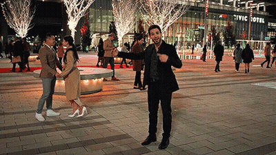 A Man Stands In Front Of A Civic Hotel At Night GIF