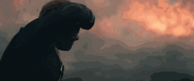A Man Stands In Front Of A Cloudy Sky With A Sunset In The Background GIF