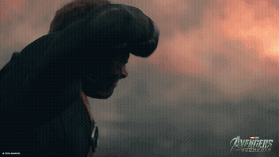 A Man Stands In Front Of A Cloudy Sky With The Avengers Logo On The Bottom GIF