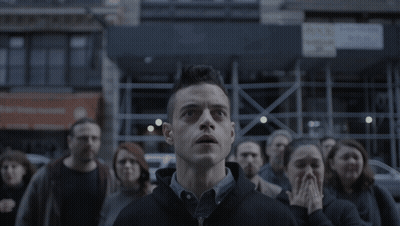 A Man Stands In Front Of A Crowd Looking Up GIF