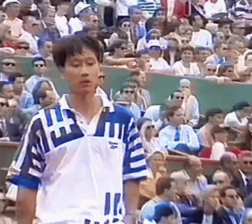 A Man Stands In Front Of A Crowd Wearing A Blue And White Shirt With The Number 11 On It GIF