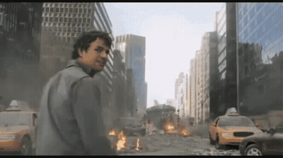 A Man Stands In Front Of A Destroyed City With A Taxi Cab In The Foreground GIF