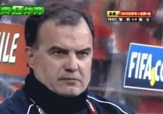 A Man Stands In Front Of A Fifa Sign GIF