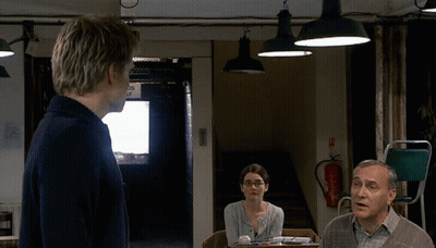A Man Stands In Front Of A Fire Extinguisher In A Room GIF