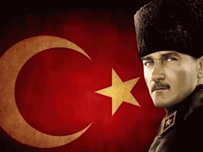 A Man Stands In Front Of A Flag With A Crescent Moon And Star GIF