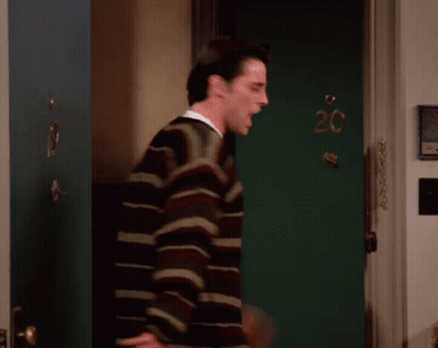 A Man Stands In Front Of A Green Door With The Number 20 Written On It GIF