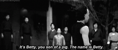 A Man Stands In Front Of A Group Of People And Says " It 'S Betty You Son Of A Pig " GIF