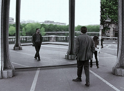 A Man Stands In Front Of A Large Mirror Looking At His Reflection In The Mirror GIF