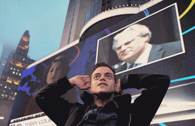 A Man Stands In Front Of A Large Screen That Says Breaking News GIF