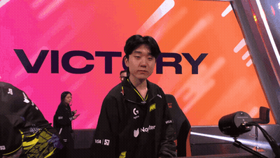 A Man Stands In Front Of A Large Victory Sign GIF